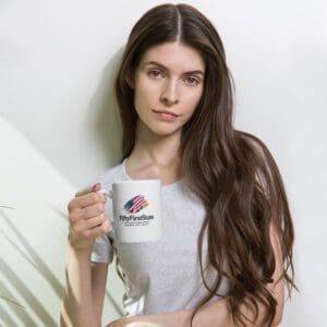 A woman holding a coffee mug in her hand.